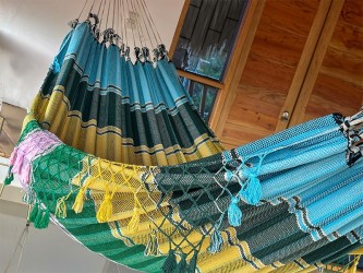 Vue complète du hamac artisanal vénézuélien avec ses couleurs vibrantes, installé en extérieur