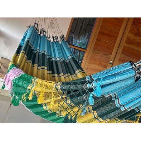 Vue complète du hamac artisanal vénézuélien avec ses couleurs vibrantes, installé en extérieur