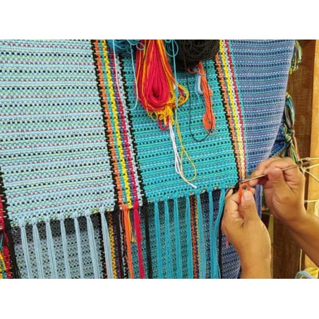 Artisane vénézuélienne en train de tisser un hamac à la main avec des fils colorés