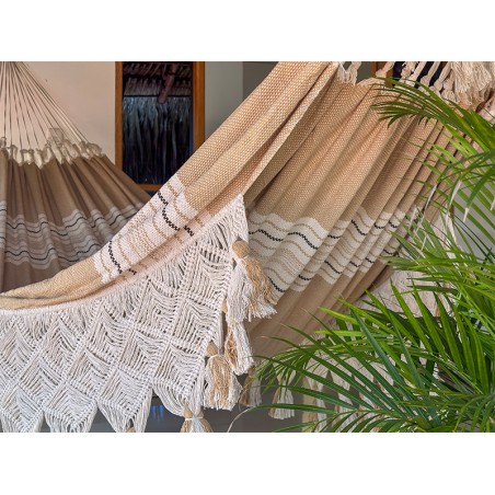 Hamac en coton tissé avec franges décoratives, suspendu entre palmiers