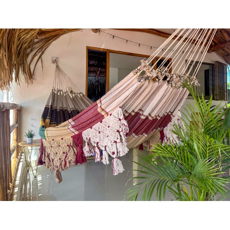 Hamac vénézuélien bordeaux et beige avec franges artisanales, suspendu en terrasse