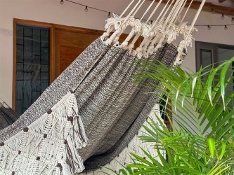 Processus de fabrication artisanale de hamacs en fil sur le métier à tisser, soulignant la tradition