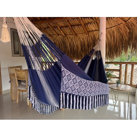 Hamac colombien taille L en tissu bleu avec des motifs blancs, suspendu sous un toit de chaume
