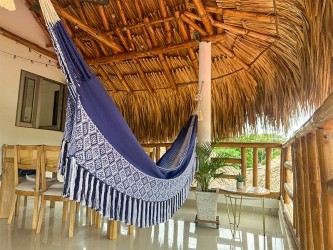 Hamac colombien taille L aux couleurs bleues et blanches, suspendu dans un cadre paisible avec vue sur la nature