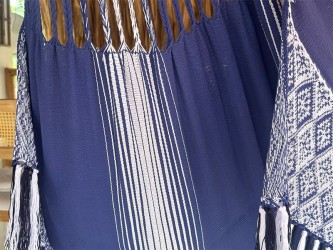 Gros plan sur les franges décoratives blanches et bleues d'un hamac colombien taille L