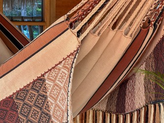 Détail de l'exquis motif tissé à la main et des franges du hamac colombien, combinant des tons terre et terracotta