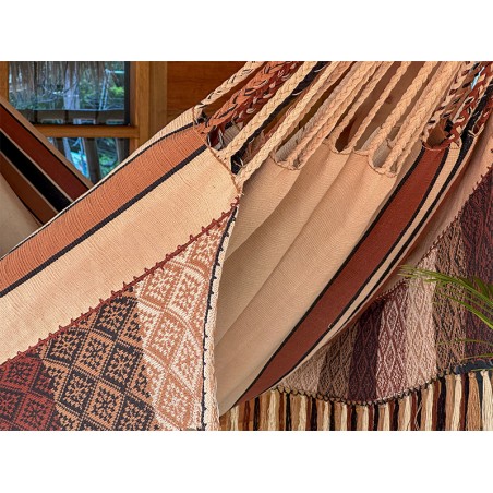 Détail de l'exquis motif tissé à la main et des franges du hamac colombien, combinant des tons terre et terracotta