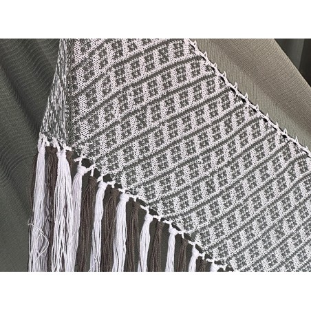 Détail rapproché du motif géométrique et de la texture du tissage d'un hamac colombien dans des tons gris-vert doux et blanc