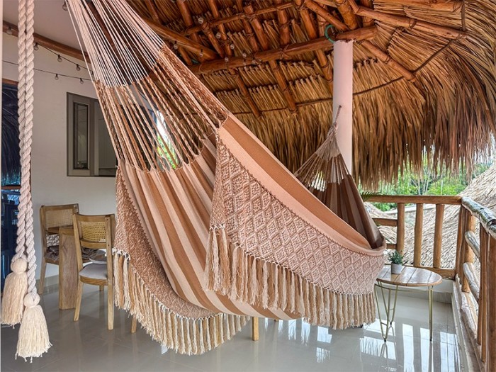 Hamac colombien en coton naturel de couleur beige, taille L, élégamment suspendu dans un environnement extérieur