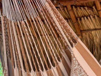 Gros plan des cordes de suspension robustes d'un hamac colombien en coton beige, démontrant la structure solide