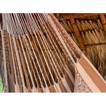Gros plan des cordes de suspension robustes d'un hamac colombien en coton beige, démontrant la structure solide