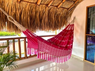 Gros plan du motif brodé artisanal détaillé et des franges aux extrémités du hamac colombien XL