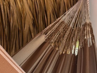 Détail du motif artisanal et des franges dans des tons marrons et beiges du bord du hamac colombien L