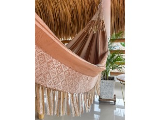 Gros plan des cordes de fixation résistantes et du début du tissage du hamac colombien L, avec ses rayures dans des tons chauds