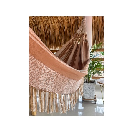 Gros plan des cordes de fixation résistantes et du début du tissage du hamac colombien L, avec ses rayures dans des tons chauds