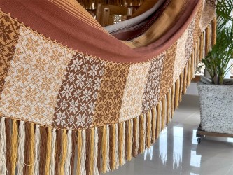 Grand hamac colombien à rayures dans des tons terre suspendu sur un porche