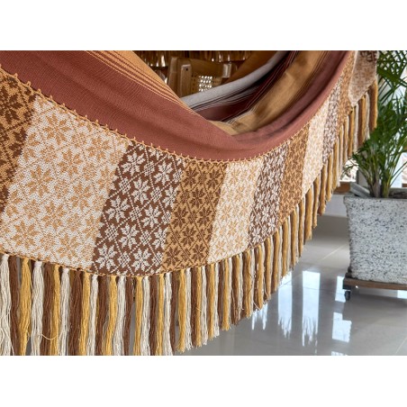 Grand hamac colombien à rayures dans des tons terre suspendu sur un porche