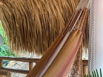 Détail des cordes de fixation résistantes et du tissage à rayures dans des tons terre du hamac colombien