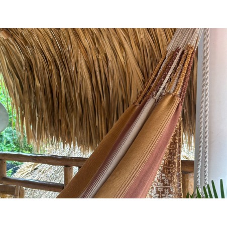 Détail des cordes de fixation résistantes et du tissage à rayures dans des tons terre du hamac colombien