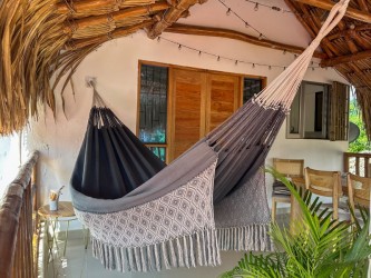 Hamac colombien XXL en gris et blanc suspendu sous un porche, combinaison de style moderne et tradition artisanale