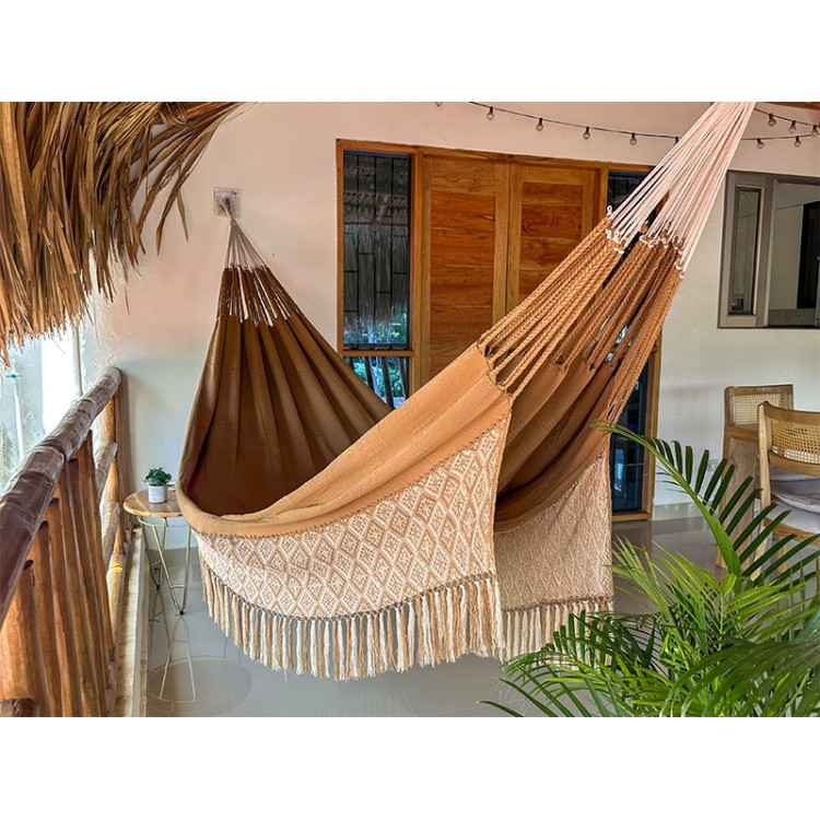 Hamac de luxe XXL DUNA dans un jardin tropical, couleur naturelle avec franges, parfait pour la détente en extérieur