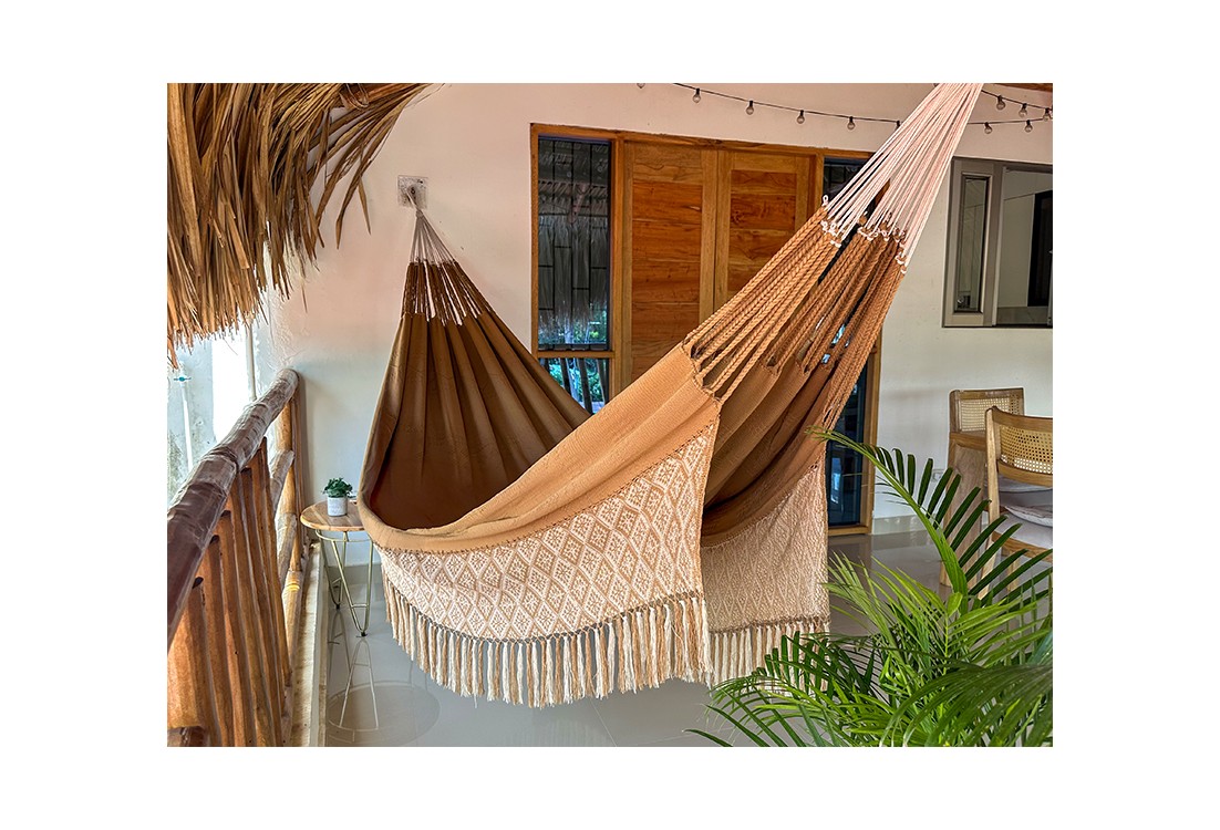 Hamac de luxe XXL DUNA dans un jardin tropical, couleur naturelle avec franges, parfait pour la détente en extérieur