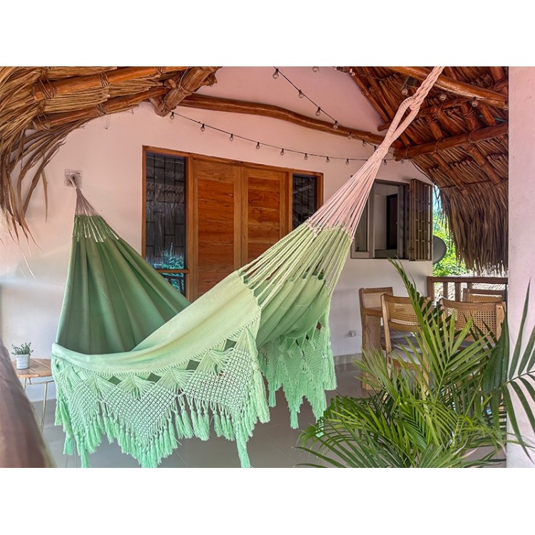 Hamac artisanal macrame colombien vert pastel XXL suspendu sur une terrasse