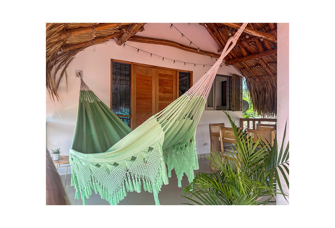 Hamac artisanal macrame colombien vert pastel XXL suspendu sur une terrasse