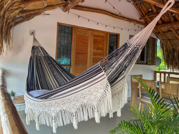 Hamac colombien artisanal XXL avec franges en macramé suspendu sur une terrasse Hamac colombien artisanal XXL avec franges en macramé suspendu sur une terrasse