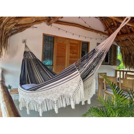 Hamac colombien artisanal XXL avec franges en macramé suspendu sur une terrasse