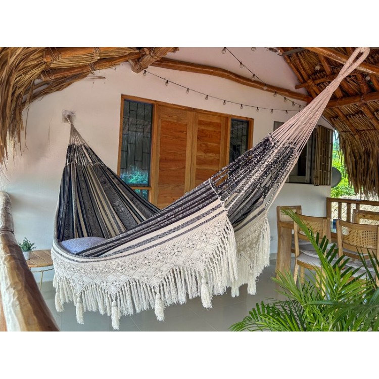 Hamac colombien artisanal XXL avec franges en macramé suspendu sur une terrasse