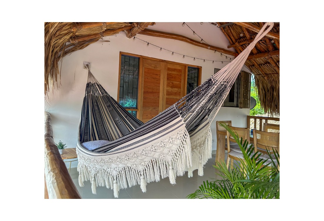 Hamac colombien artisanal XXL avec franges en macramé suspendu sur une terrasse