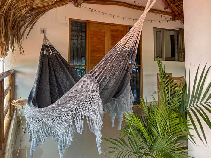 Hamac colombien artisanal gris XXL suspendu sur une terrasse en bois Hamac colombien artisanal gris XXL suspendu sur une terrasse en bois