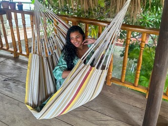 Hamac chaise colombien XXL en usage, femme souriante en coton recyclé