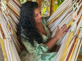 Fille montrant une toile de hamac chaise à rayures et couleurs terre