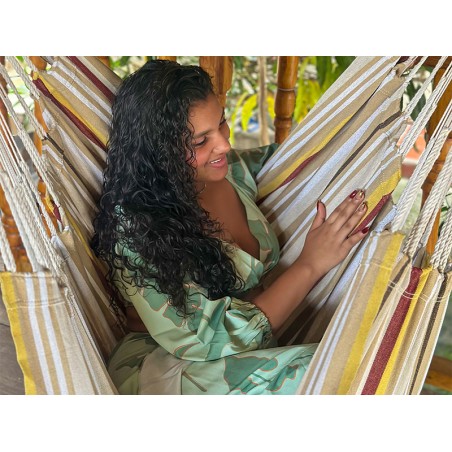 Fille montrant une toile de hamac chaise à rayures et couleurs terre