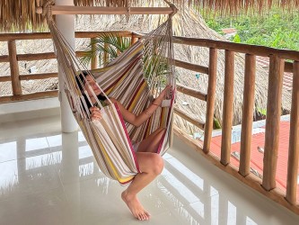 Femme détendue dans un hamac chaise XL colombien, ambiance tropicale, coton recyclé
