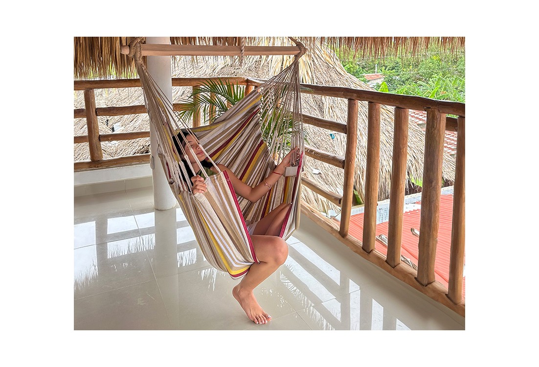 Femme détendue dans un hamac chaise XL colombien, ambiance tropicale, coton recyclé