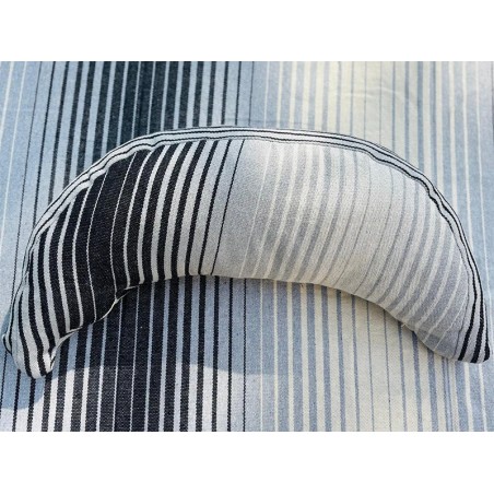 Coussin sur un hamac en tissu à rayures grises et blanches, sur un tissu de texture similaire