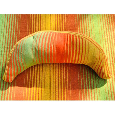 Coussin sur un hamac en tissu à rayures verts et oranges, sur un tissu de texture similaire
