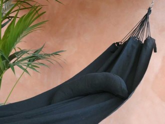 Coussin cervical en tissu noir, en forme de demi-lune, sur un hamac de même texture