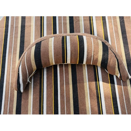 Coussin sur un hamac en tissu à rayures marron et blanches, sur un tissu de texture similaire