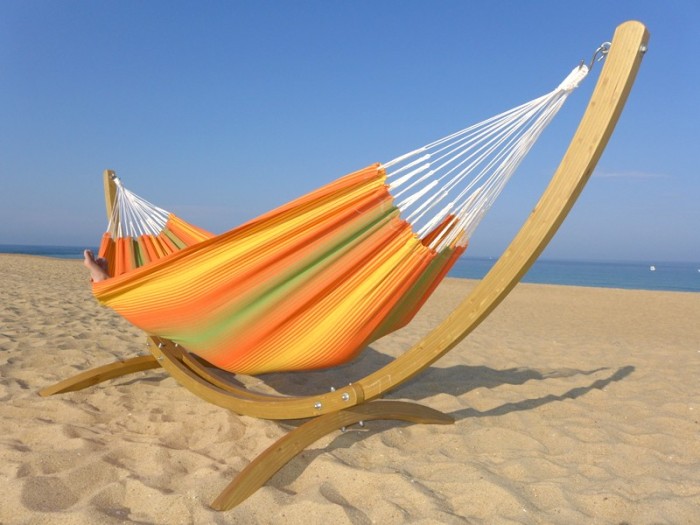 Hamac avec rayures orange et vertes avec support face à la mer, vue de profil