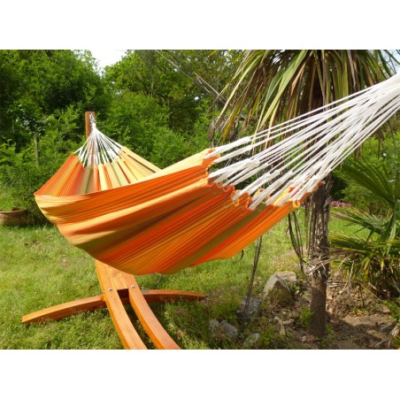 Hamac artisanal colombien suspendu sur un support en bois dans un espace vert