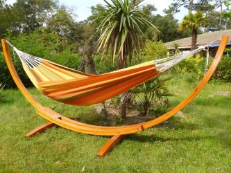 Grand hamac coloré avec structure en bois dans un jardin ensoleillé