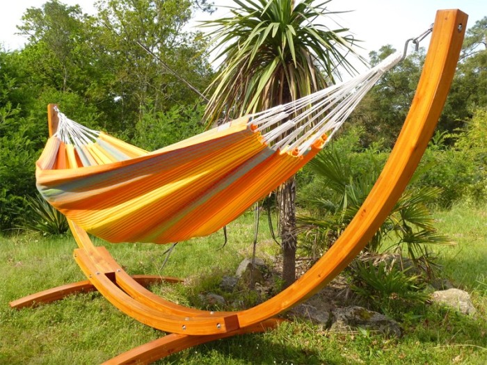Hamac colombien multicolore avec support en bois courbé dans un jardin tropical