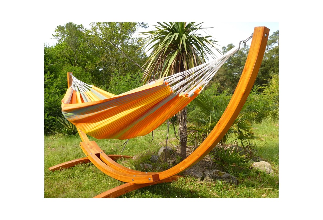 Hamac colombien multicolore avec support en bois courbé dans un jardin tropical
