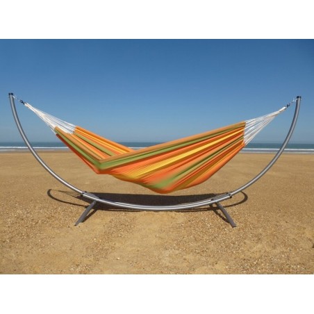Hamac XXL en toile colorée sur support métallique, installé en extérieur sur le sable
