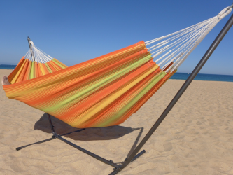 Hamac multicolore orange et vert avec support métallique noir sur la plage