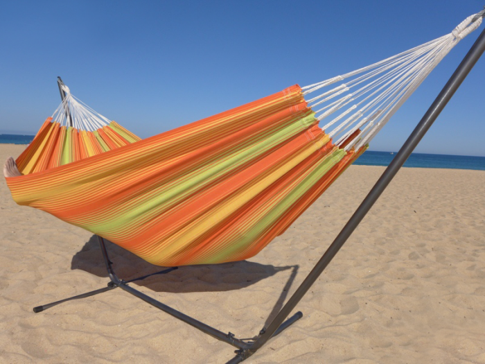 Hamac multicolore orange et vert avec support métallique noir sur la plage